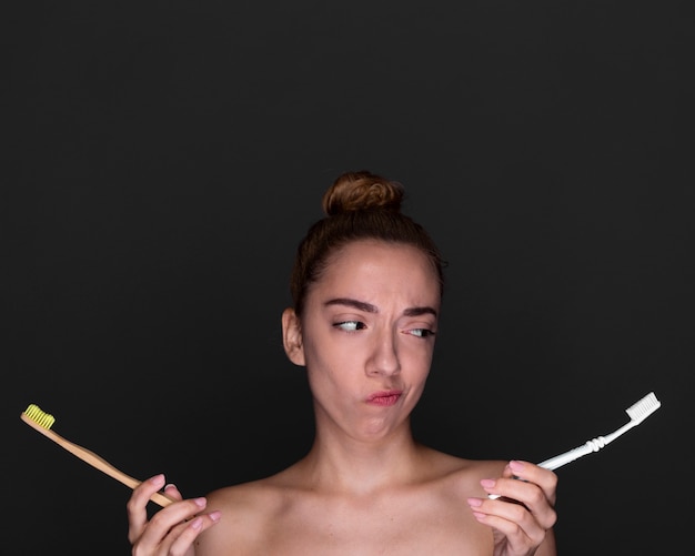 Free photo front view girl holding toothbrushes