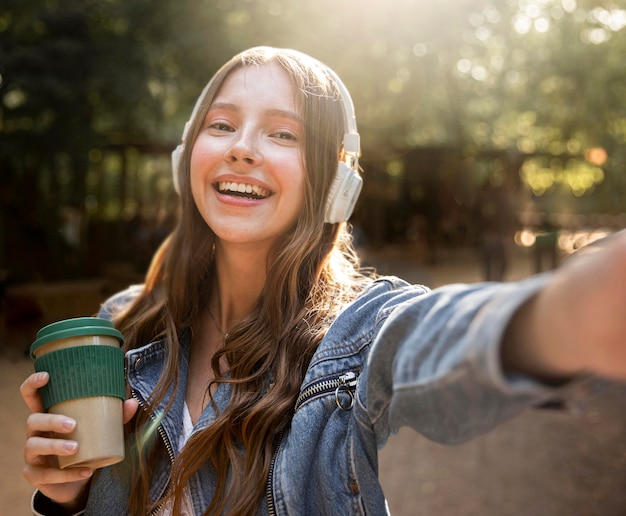 Foto gratuita musica d'ascolto della ragazza di vista frontale alle cuffie