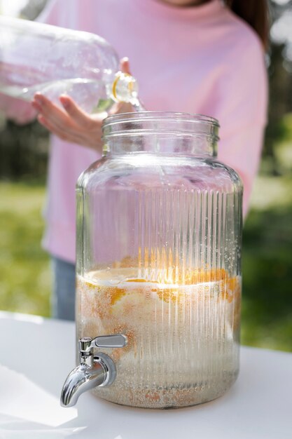 Front view girl making fresh lemonade