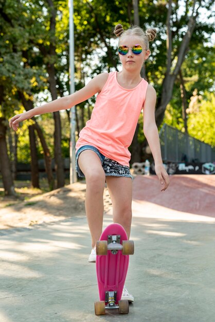 Front view of girl on pink skateboard