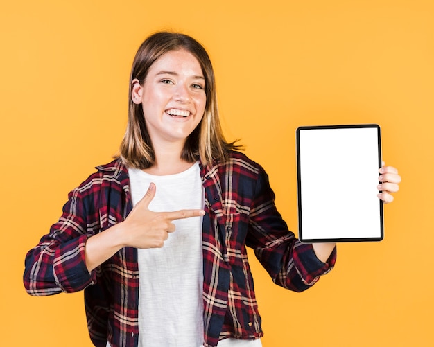 Free photo front view girl pointing at a tablet