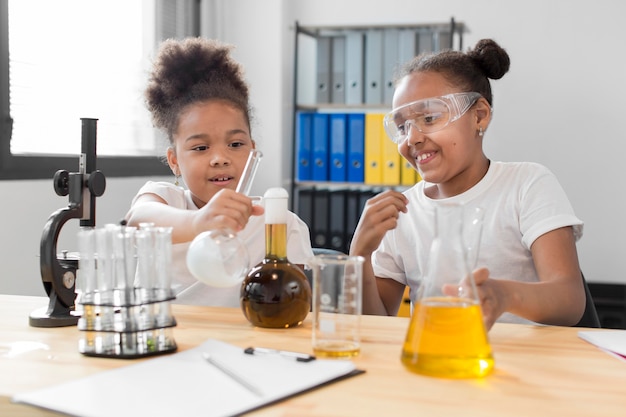 Front view of girl scientist experimenting with chemistry at home