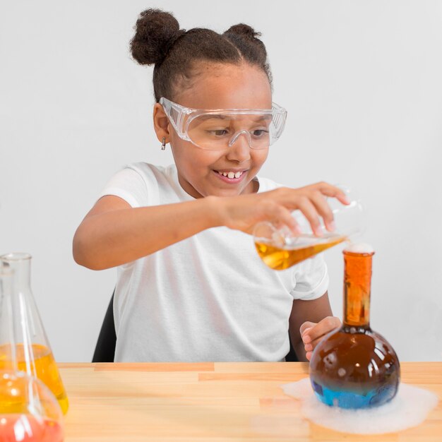 Front view of girl scientist experimenting with potions