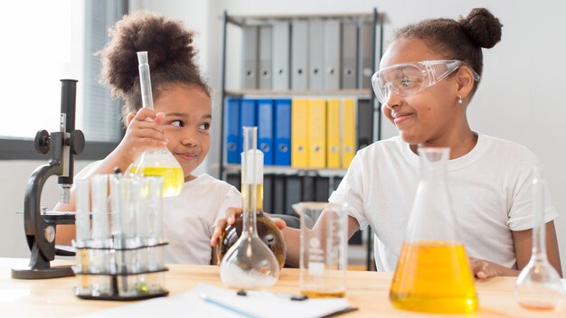 Front view of girl scientists at home experimenting with chemistry