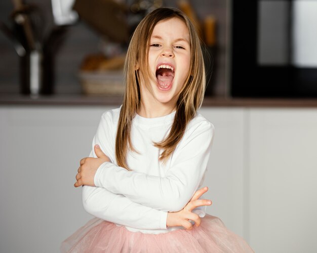 Front view of girl in tutu skirt with mouth wide open
