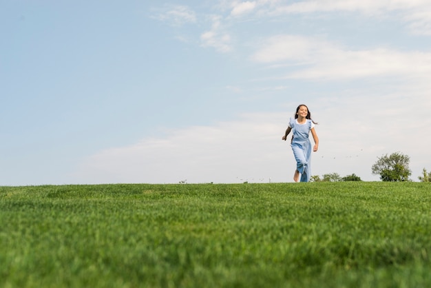 Front view girl walking barefoot on grass