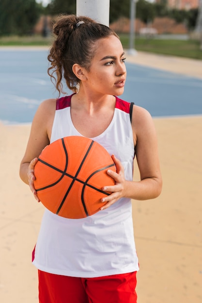 Vista frontale della ragazza con la palla da basket