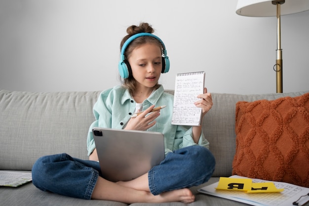 Front view girl with tablet and headphones