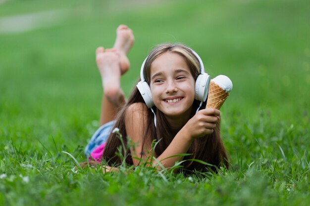 バニラアイスクリームを持つ少女の正面図