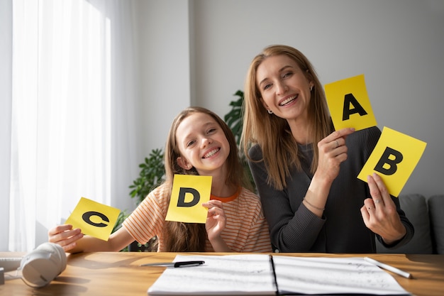 Front view girl and woman holding cards