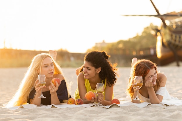 Front view of girls drinking wine at beach