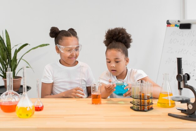 Front view of girls experimenting chemistry at home