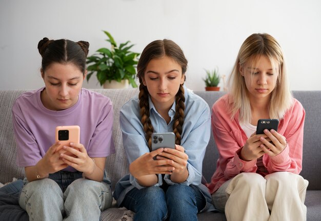 Девушки, вид спереди, держат смартфоны