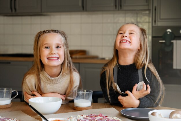 Front view girls making pizza at home