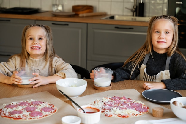 Free photo front view girls making pizza