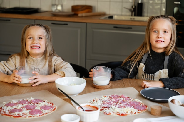 Девушки, вид спереди, готовят пиццу
