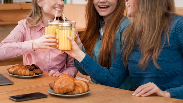 Vista frontale delle ragazze che si siedono al tavolo