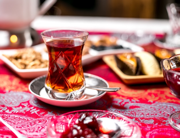 Front view a glass of armudu with tea and cherry jam