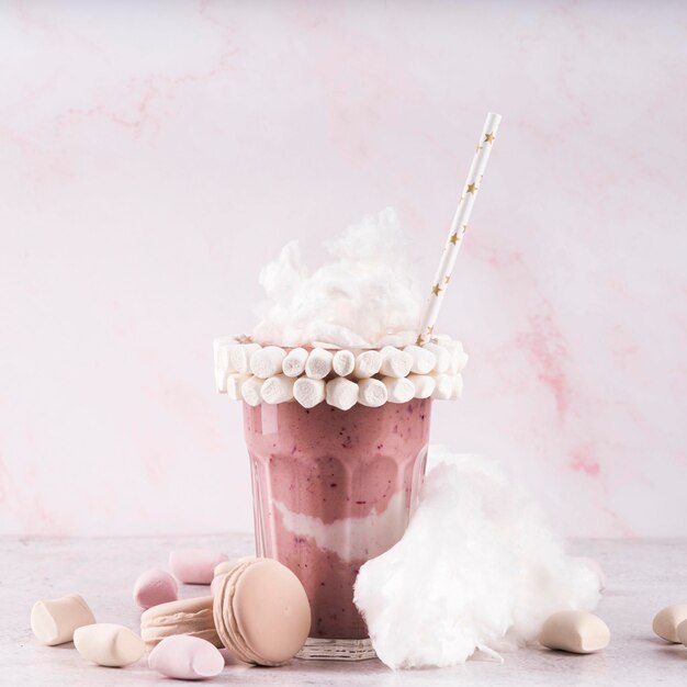 Front view of glass of dessert with marshmallows and cotton candy