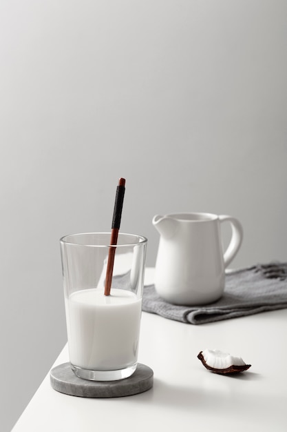 Free photo front view of glass of milk with coconut