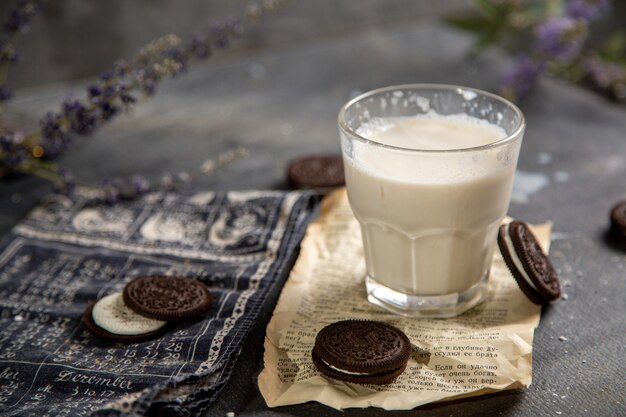 グレーのデスクビスケット砂糖甘いクッキーミルクにおいしいチョコレートクッキーとミルクの正面図ガラス