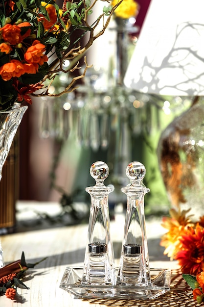 Front view glass set for salt and pepper and a long glass set for spices on a glass plate