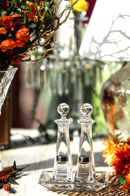 Front view glass set for salt and pepper and a long glass set for spices on a glass plate