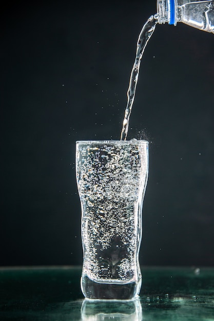 Front view glass of soda getting poured on the dark drink photo champagne xmas water