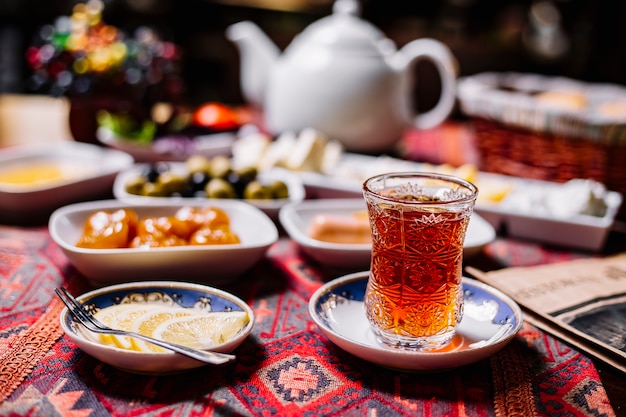 Free photo front view a glass of tea in armudu with lemon slices