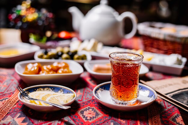 Front view a glass of tea in armudu with lemon slices