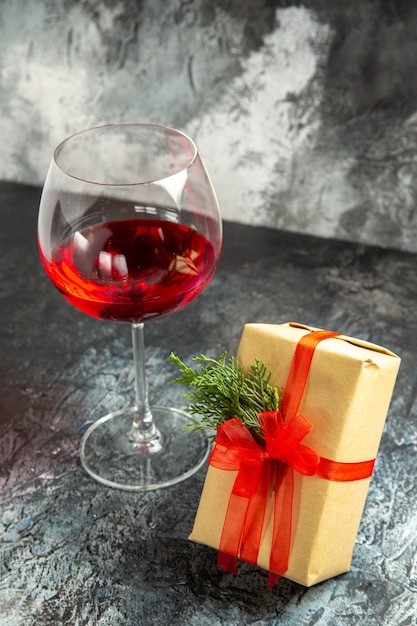 Free photo front view glass of wine gift on dark background