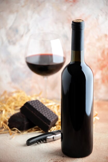 Front view glass of wine with bottle and chocolate on a light background alcohol lemonade holiday bar champagne juice dinner drink