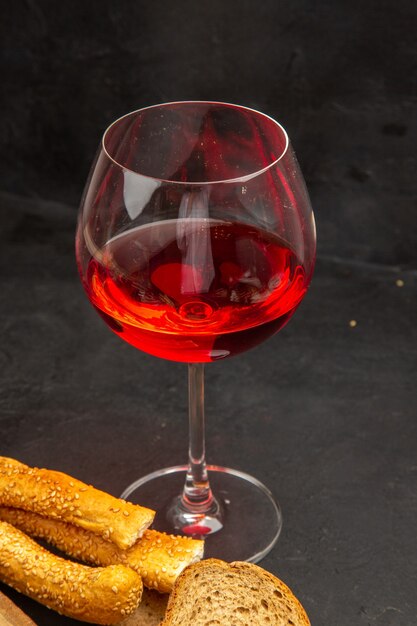 Front view glass of wine with buns and bread on dark color snack beer alcohol photo