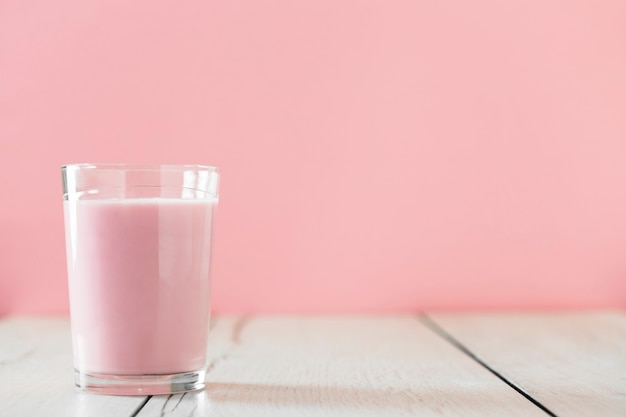 Вид спереди стекла с розовым молочным коктейлем