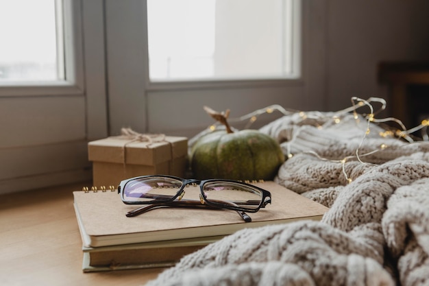 Free photo front view glasses on agendas with pumpkin and blankets