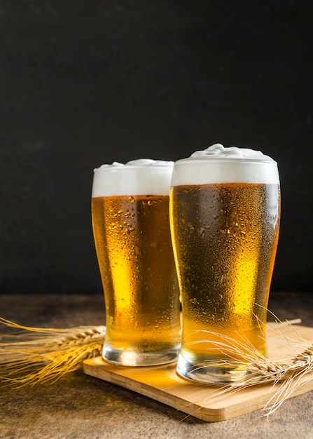 Free photo front view of glasses of beer with wheat