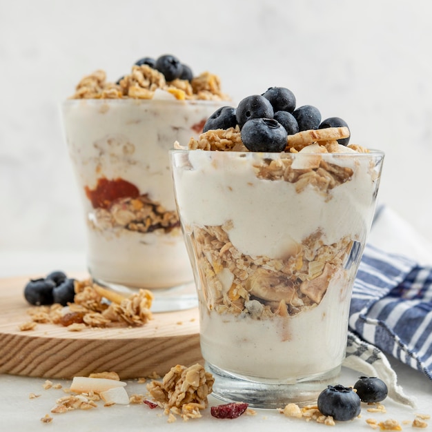 Front view of glasses with yogurt and breakfast cereals