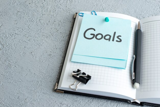 front view goals written note with pen on white background