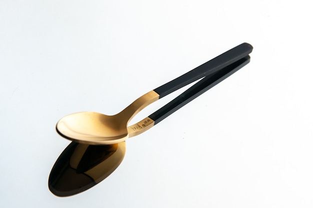 front view golden spoon on white background