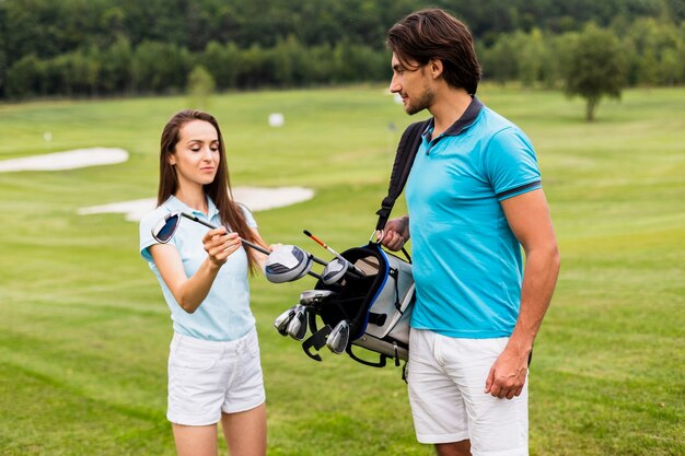 Front view of golf players looking at a club