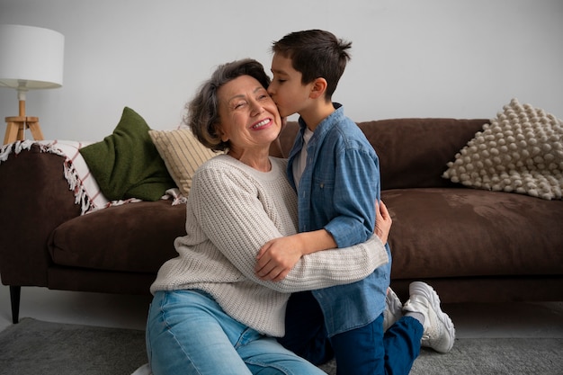 Front view of grandchild kissing his grandmother on the cheek