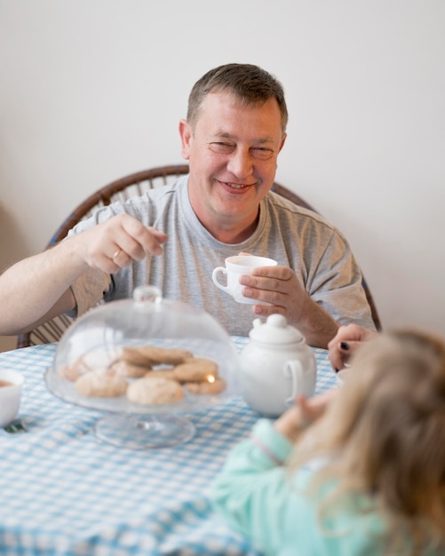 Free photo front view of grandfather and granddaughter at lunch