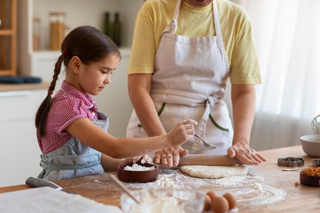 Free photo front view grandma and girl cooking together