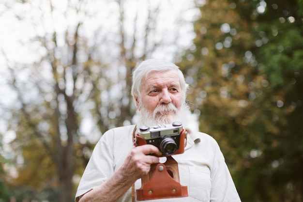 Free photo front view grandpa with camera outdoor