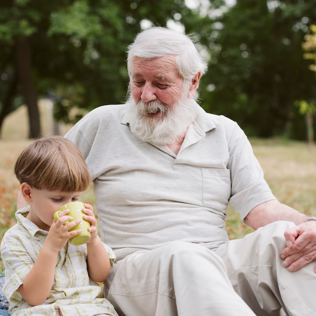 Front view grandson with grandpa drinking tea