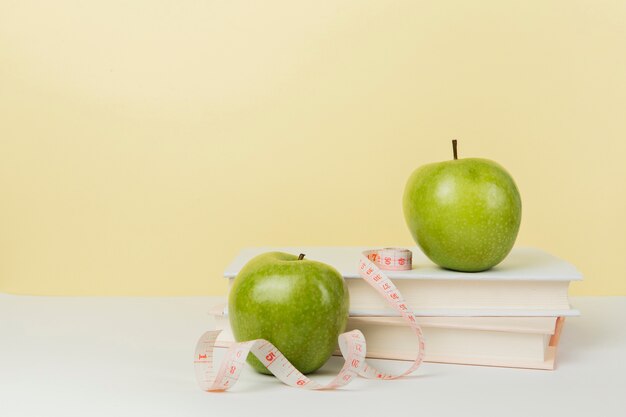 Front view of green apples on books with copy space