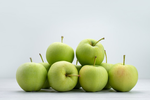 Front view green apples lined on grey