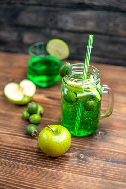 Front view green feijoa juice inside can with green apples on a wooden desk bar fruit color drink photo cocktail