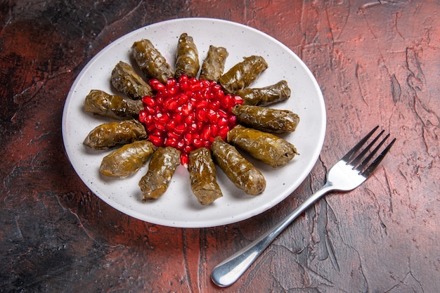 Foto gratuita vista frontale del dolma foglia verde con melograni sulla superficie scura