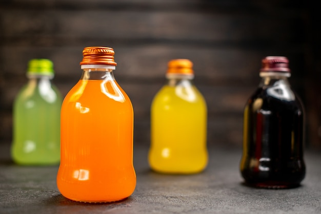 正面図緑、オレンジ、黄色、黒のフルーツジュースボトル